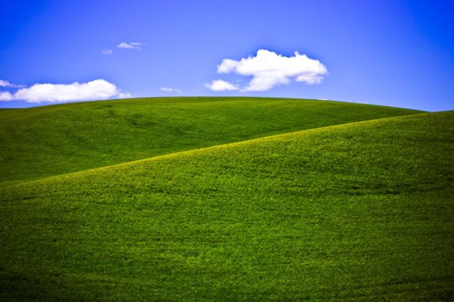 Rolling green hills under a blue sky with clouds