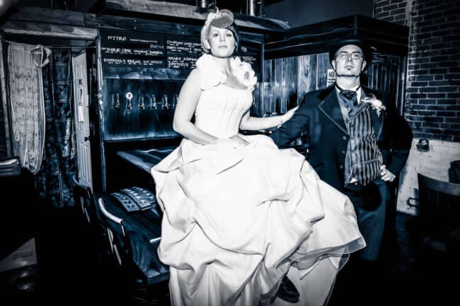 Vintage-style black and white portrait of a bride in a wedding gown with birdcage veil and groom in a period suit at Portal Brewing Company