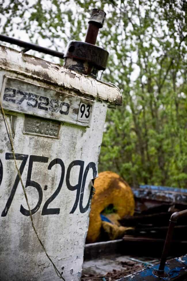 Close-up of registration numbers painted on the weathered hull of an abandoned boat