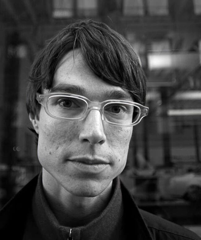 Black and white portrait of a young man with glasses
