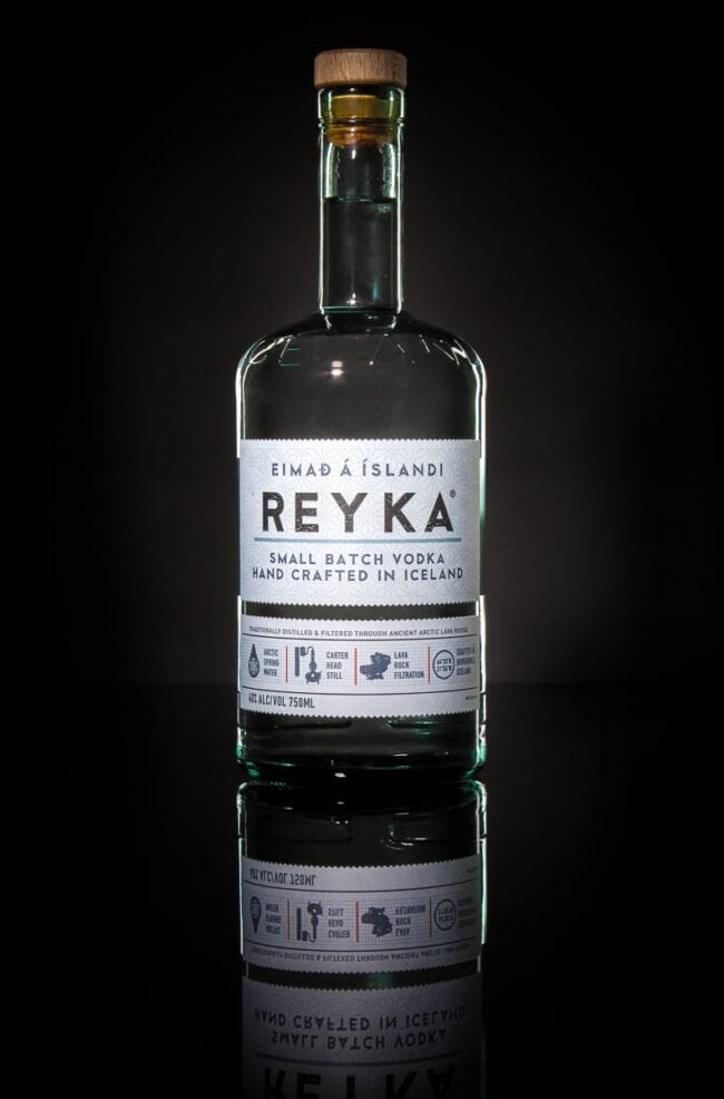 Bottle of Reyka small batch vodka on a dark reflective surface