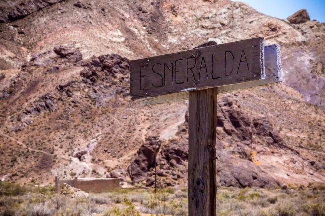 A weathered sign in the Nevada desert reading "Esmeralda" in faded lettering
