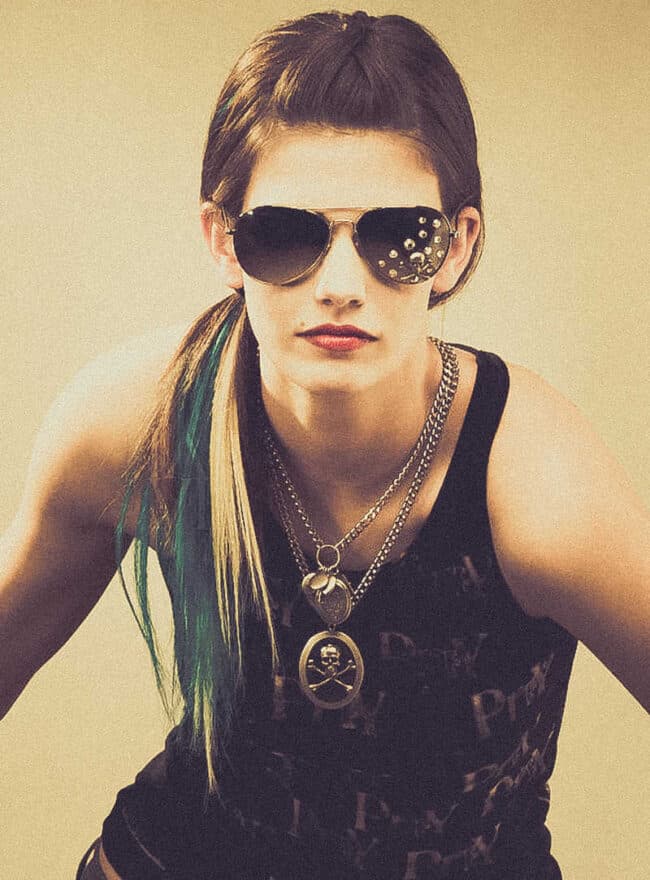 Fashion portrait of a woman in sunglasses and layered necklaces wearing a dark graphic tank top