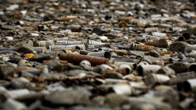 A close-up of a beach covered in weathered, colorful sea glass and pebbles