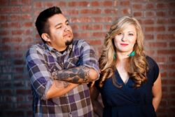 Man and woman posing together against a brick wall