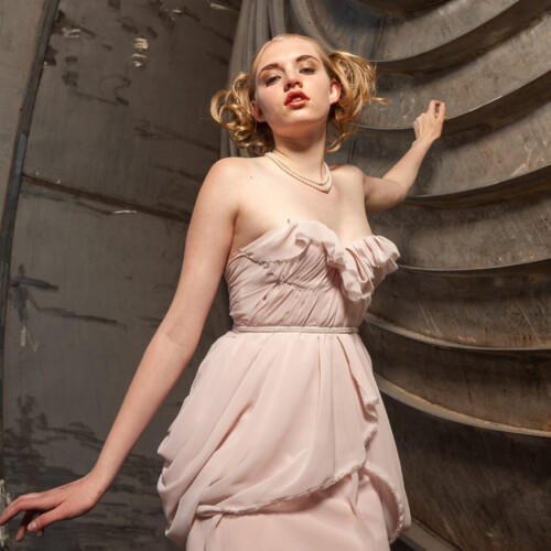 Three-panel vintage 1920s-style fashion triptych: a close-up of a feathered and beaded headpiece, a woman in a blush pink ruffled dress against a corrugated metal barrel backdrop, and a woman in a sage green dress against a teal background