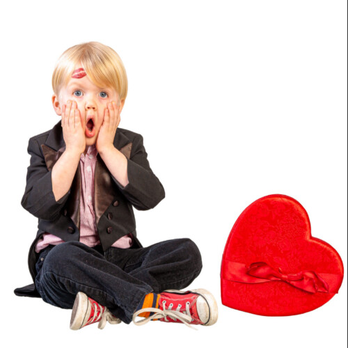 Three-panel Valentine's Day-themed triptych of a blonde toddler boy holding a rose, reacting in surprise beside a heart-shaped box with a lipstick kiss mark on his cheek, and posing in sunglasses