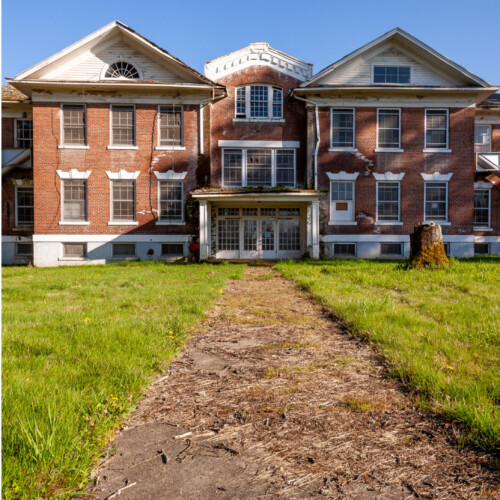 Three-panel triptych: a black-and-white close-up of ornate metal chain stays on a weathered ceiling surface, a color photo of an abandoned brick institutional building with an overgrown path, and a black-and-white close-up of an old metal playground slide against trees